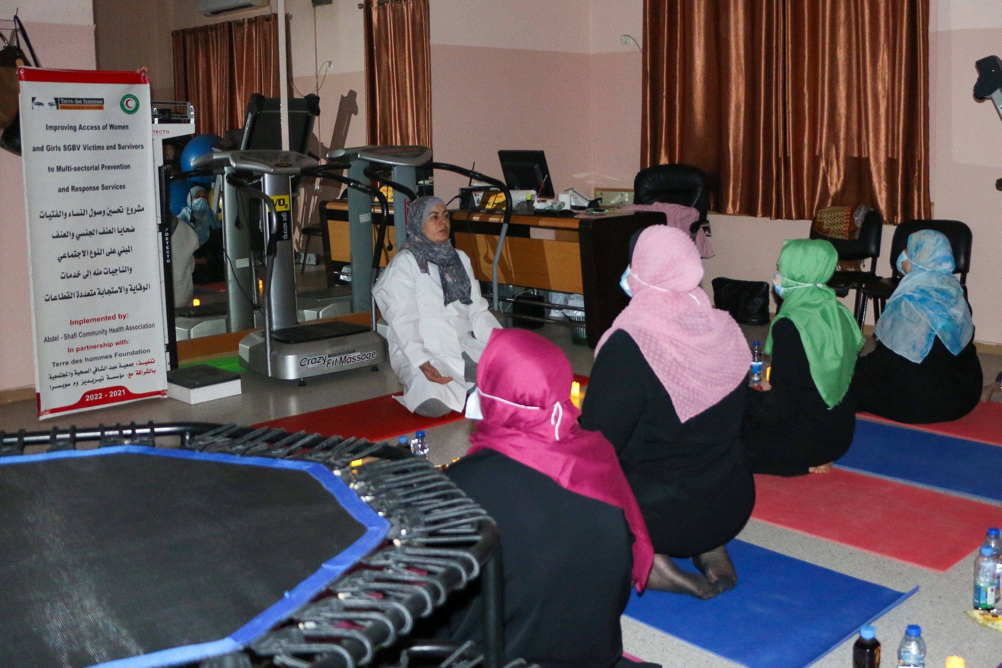 photo showing women kneeling on mats for yoga class
